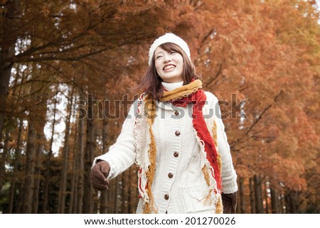 A Woman Walking In Autumn Leaves