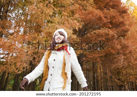 A Woman Walking In Autumn Leaves