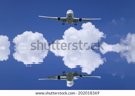 White Clouds And A Passenger Plane Reflected On The Surface Of Water