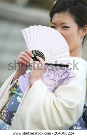 The Woman Wearing A Kimono With A Fan