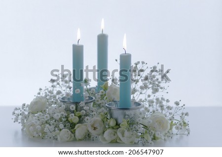 Flower Arrangment Of The White Flower And The Blue Candle