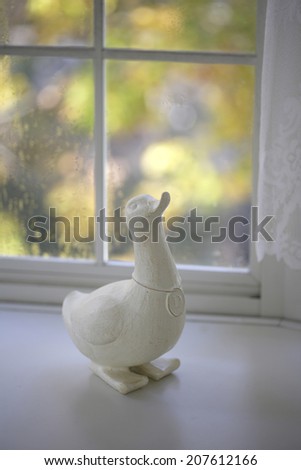 The White Window-Side And A Wooden Duck In Autumn