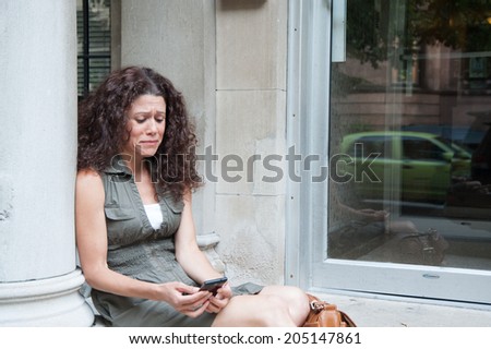 Women sitting on the porch upset with the phone in her hands