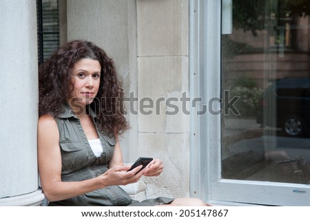 women sitting on the porch with the phone in her hands