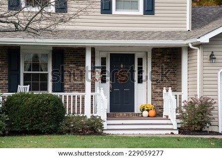 Front porch of suburban home decorate for fall holidays