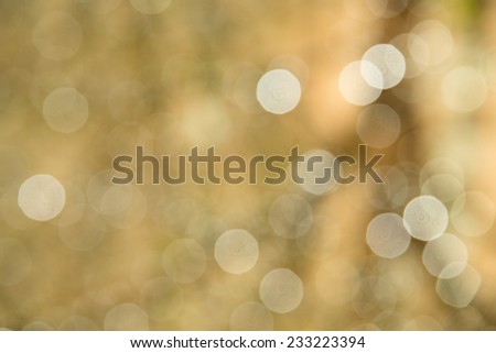 Defocused holiday background with gold tones and sparkle circles
