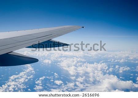 Airplane wing above the clouds - fling south