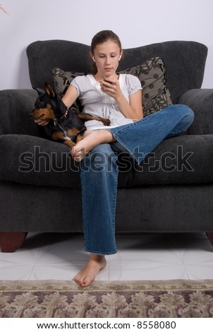 young girl in the chair with the dog, listening to a music