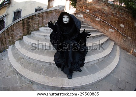 Man in dark halloween like costume on streets of Venice during carnival