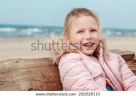 girl smiling on the beach in the cold season