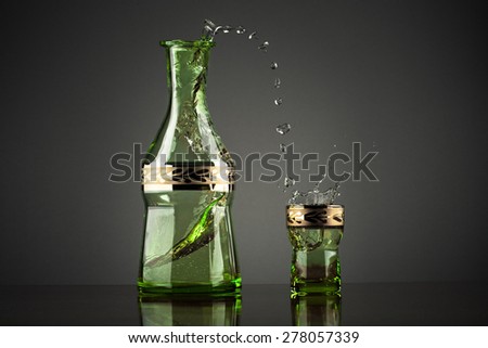 Splashing drink vodka on grey background