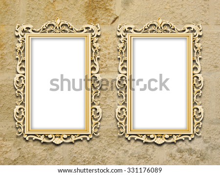 Two golden baroque picture frames on grungy yellow concrete wall background