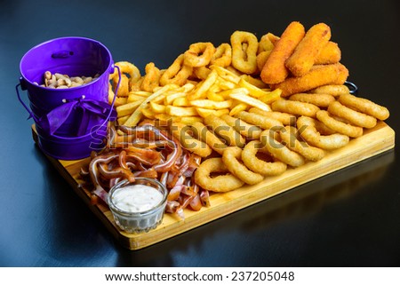 fried onion rings, Colmar, cheese, french fries, peanuts, pork ears on a wooden board