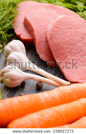 raw meat with garlic and carrot on the table