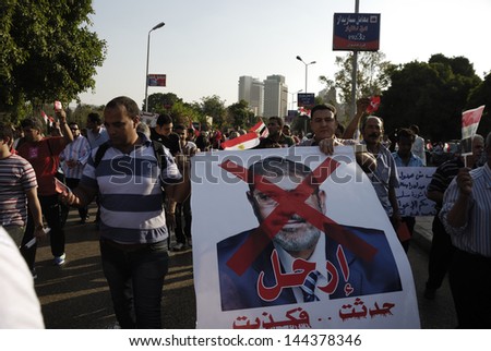 Cairo - June 30: Anti Muslim Brotherhood/Morsi Protesters In El-Tahrir Street Hold A Photograph Of The President Muhammad Morsi With A Text Says &Quot;Go Away!&Quot; June 30, 2013 In Cairo, Egypt