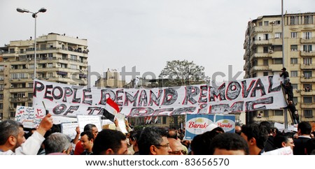 CAIRO - FEB 1: A large group of Egyptian anti-government protesters attach a big banner to light poles in Cairo, Egypt\'s central Tahrir Square on  Feb 1, 2011.