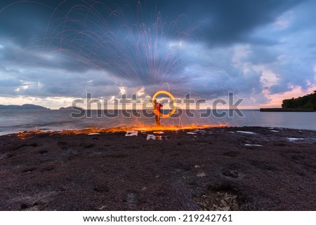 Fire dancing steel wool coast the sea in the twilight