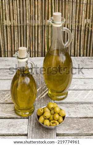 Olives and olive oil in a bowl on a wooden table