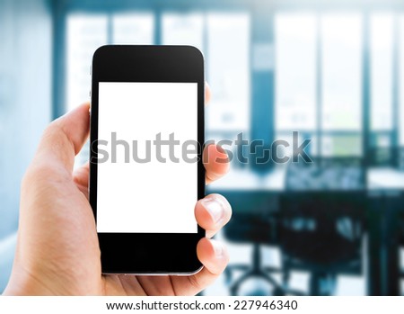 Close up hand holding smart phone with blank screen on meeting room background