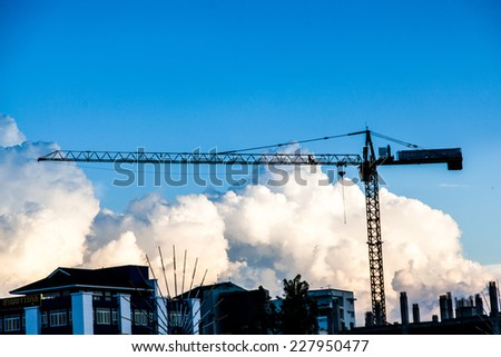 Industrial construction cranes and building silhouettes