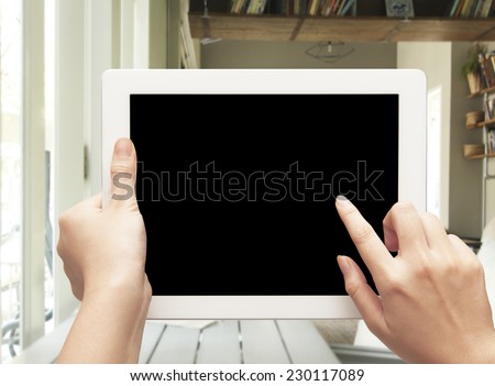 female teen hands using tablet pc with black screen on blurred cafe background