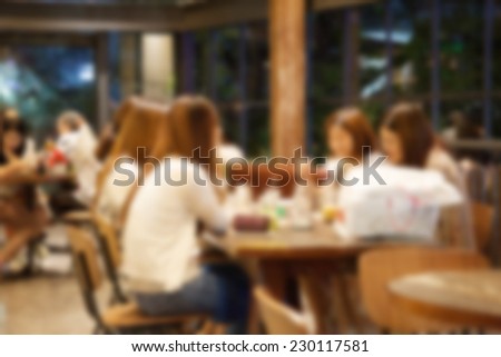 blurred silhouettes of sitting people in coffee cafe