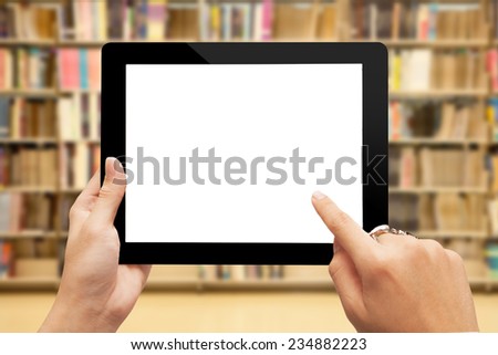 male teen hands with ring using tablet pc on library background