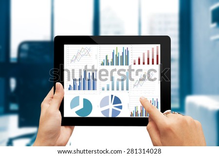 Closeup hand holding digital tablet show analyzing graph with conference room background