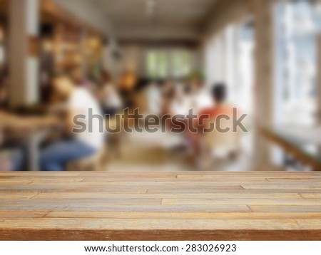 Empty wooden table and blurred people in cafe background, product display