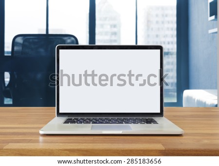 Laptop on table, on office background,blank screen