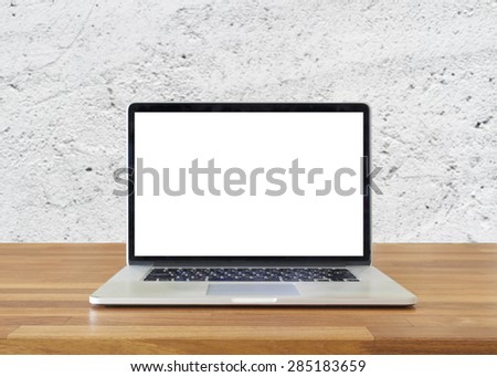 Laptop on table, on  white cement wall background,blank screen