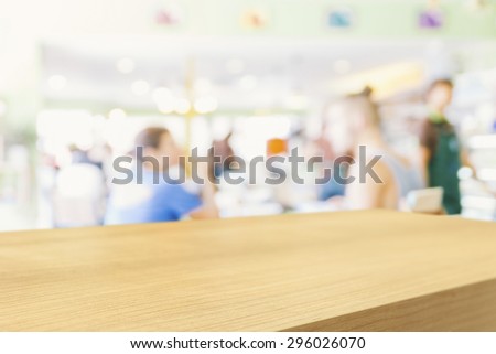 Empty wooden table and blurred people in cafe background, product display montage