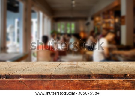Empty wooden table and blurred people in cafe background, product display montage