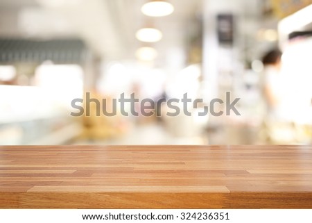 Empty wooden table and blurred people at supermarket background, product display montage