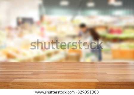 Empty wooden table and people shopping at supermarket  background, product montage display