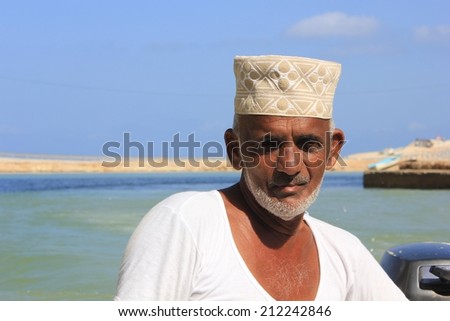 Sur, Oman, October 23, 2013: Omani fisherman at work. He is wearing the traditional omani hat, the kumma, used during unofficial time.