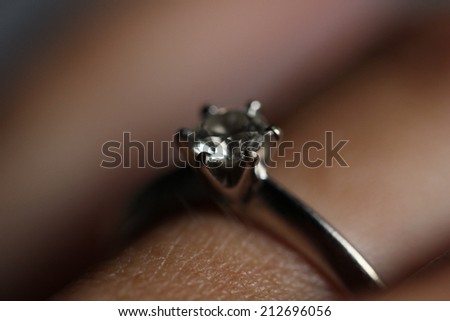 Engagement Ring. A ring with a diamond in the centre on woman\'s finger.