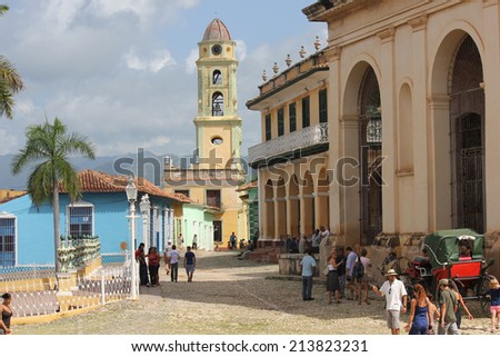 Trinidad, Cuba, August 18, 2012: Daily Life in Trinidad, Cuba. People in the main square. In the background, the city\'s main church and the coloured typical houses.