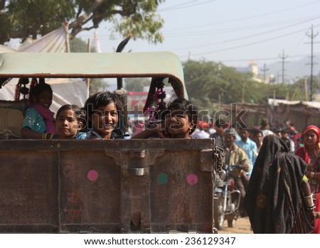 PUSHKAR, INDIA - NOV 28: Children on a truck in Pushkar, going to the famous Camel fair and smiling at the camera on November 28 2012