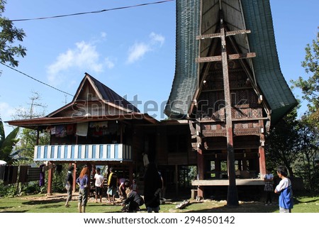 SOUTH SULAWESI, INDONESIA - JULY 4 2012: Typical Torajan houses, called Tongkonan, in a sunny day with tourists around