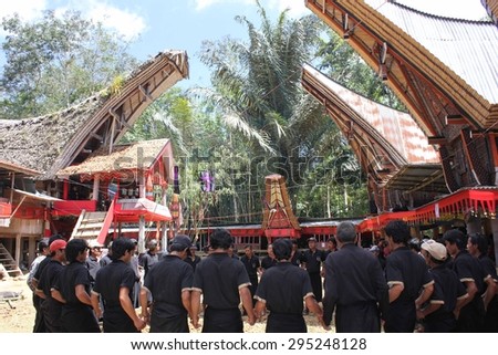 TANA TORAJA, INDONESIA: People in black at a funeral ceremony in the Sulawesi, with the traditional torajan houses