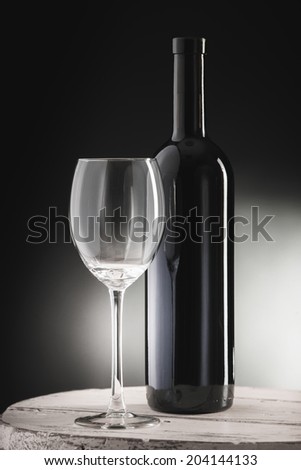 Red wine bottle and wine glass on wodden barrel