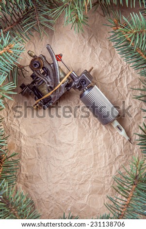 Pine branch with tattoo machine shader on paper background. Copy space
