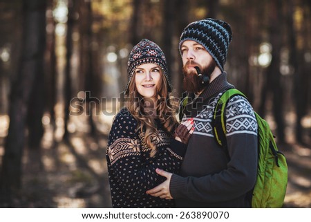 Outdoor happy couple. The bearded guy with tobacco pipe