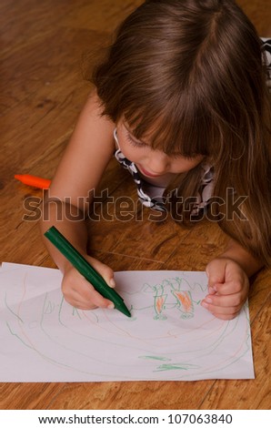 girl laying on floor drawing
