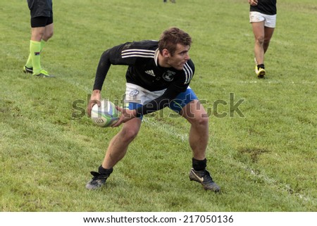ZAGREB, CROATIA - SEPTEMBER 13, 2014: Rugby match Rugby Club Zagreb in white jersey and Rugby Club Sinj in black jersey. Unidentified player passing the ball.