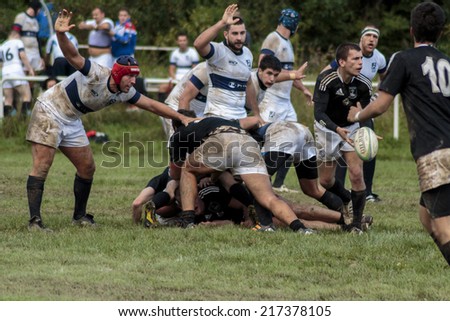 ZAGREB, CROATIA - SEPTEMBER 13, 2014: Rugby match Rugby Club Zagreb in white jersey and Rugby Club Sinj in black jersey. Unidentified player\'s tackle each other and passing ball