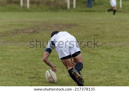 ZAGREB, CROATIA - SEPTEMBER 13, 2014: Rugby match Rugby Club Zagreb in white jersey and Rugby Club Sinj in black jersey. Unidentified player run to grab a ball.