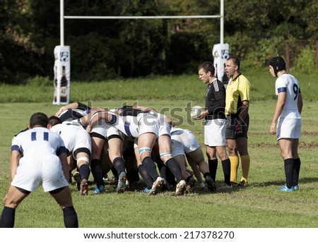 ZAGREB, CROATIA - SEPTEMBER 13, 2014: Rugby match Rugby Club Zagreb in white jersey and Rugby Club Sinj in black jersey. Referee sets the unidentified players in the formation.