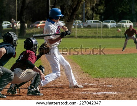 ZAGREB. CROATIA - OCTOBER 11, 2014: Baseball match Baseball Club Zagreb in white jersey and Baseball Club Medvednica in red jersey. Unidentified baseball player swinging baseball bat to hit the ball